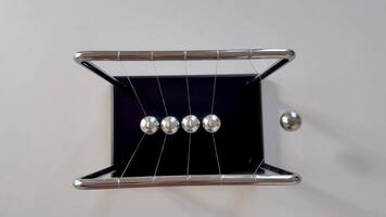 A Newtons Cradle, elegantly displaying the essential principles of momentum and energy transfer using steel balls photo