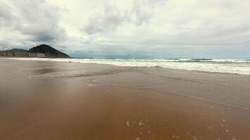 A tranquil and serene beach with soft, gentle waves and an overcast sky, perfect for relaxation and peaceful escape photo