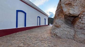Stroll a charming stone pathway by a cliff, showcasing vibrant architecture and stunning panoramic views photo