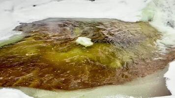 A stunning view of water cascading beneath ice, showcasing natures beauty and the contrast it presents photo