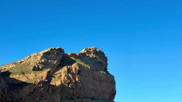 The captivating rocky shoreline features clear blue skies and calm waters, making it perfect for nature enthusiasts photo