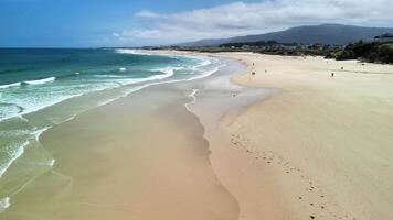 A breathtaking beach landscape featuring soft waves gently breaking on golden sand, creating a serene atmosphere photo