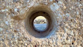 A distinctive perspective observed through a circular stone opening that reveals the captivating beauty of nature photo