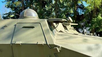 A closeup of a military vehicle highlights its turret and advanced weaponry, placed in a natural setting photo