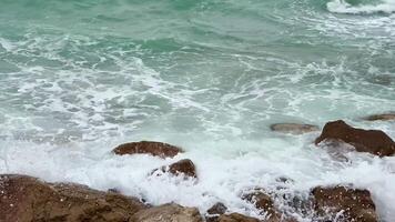 Serene, gentle waves repeatedly wash over the rugged coastal rocks in a beautifully tranquil seascape setting photo