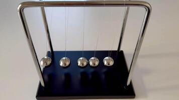 A classic Newtons Cradle elegantly showcasing the fascinating principles of momentum and energy transfer in action photo