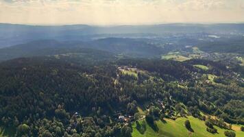 A breathtaking aerial shot that beautifully showcases expansive green forests and valleys beneath a clear sky photo