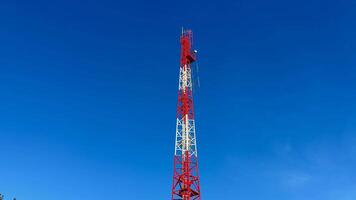 A tall and sturdy telecom tower representing modern communication technology set against a bright blue sky photo