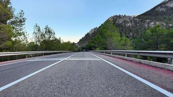 A beautiful winding road in a breathtaking mountainous landscape with vibrant trees and clear blue skies photo