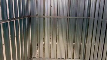 An interior view showcasing an empty metal storage container that features vertical metal slats throughout photo