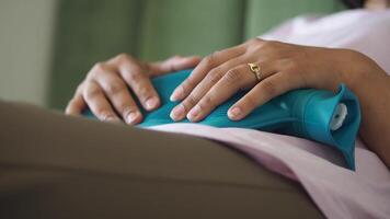 Relaxing on sofa with heating pad for discomfort relief video