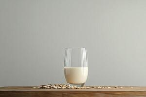 Oat milk in a glass with oats nearby on a wooden surface photo