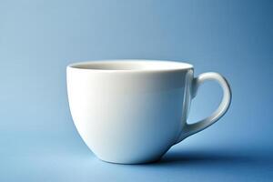 A single white cup sits on a blue background photo