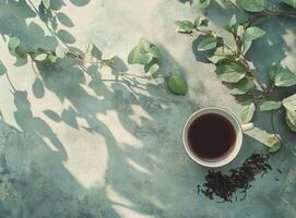 A cup of tea rests among leafy branches and shadows photo