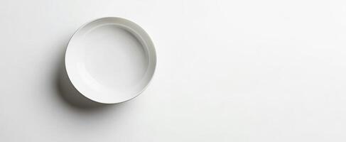 A single empty white bowl sits on a white background photo