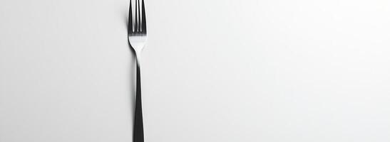 A single metallic fork on a white background photo