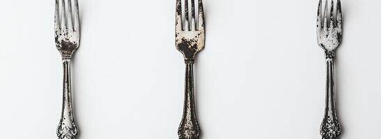 Three Antique Forks Arranged Vertically on White Background photo