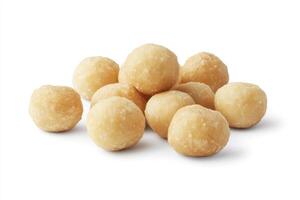 A pile of roasted macadamia nuts sits on a white background photo