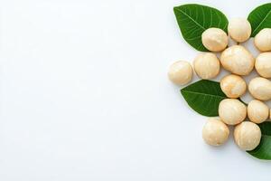 Macadamia nuts and leaves on white background photo