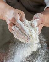 A person is sprinkling flour on a table photo