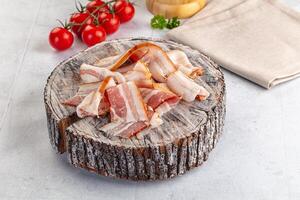 Bacon on a wooden stump with tomatoes and a napkin photo
