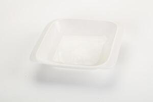 A white plastic bowl with a lid on a white surface photo