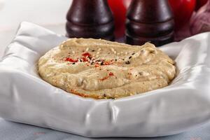 A bowl of hummus with red peppers photo