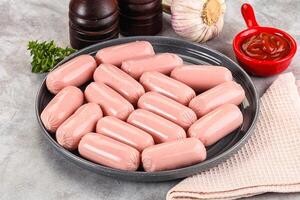 A plate of sausages on a table with garlic and other spices photo