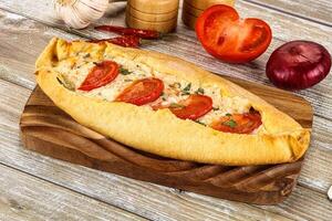 A bread roll with tomatoes and onions on it photo