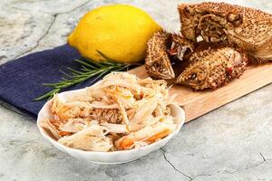 A plate with crab legs and a lemon photo