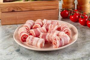 A plate of bacon rolls on a table photo