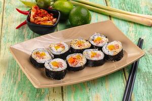 Sushi rolls with vegetables and chopsticks on a wooden table photo