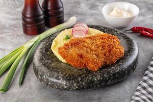 Fried chicken with mashed potatoes and onions on a stone plate photo