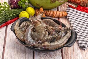 A bowl of shrimp sitting on a table next to a bowl of vegetables photo