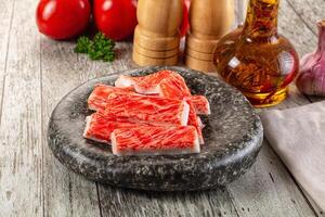 A bowl of raw meat on a table next to a bottle of oil photo