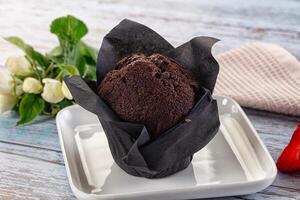 A chocolate muffin on a plate with flowers photo