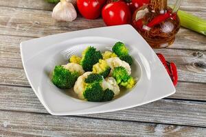A white plate with broccoli and garlic on it photo