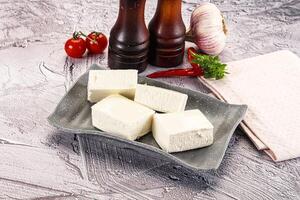 A plate with some cubes of cheese and some tomatoes photo