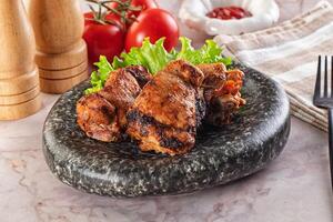 A plate with some chicken wings and tomatoes photo