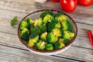 Broccoli in a bowl with tomatoes and garlic photo