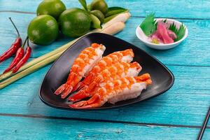 A plate with shrimp and other ingredients on a blue table photo