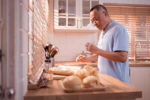 Happy Asian grandfather enjoying cooking the mealtime in the kitchen,55 photo