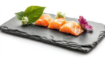 Fresh salmon sashimi, three pieces on slate, garnished photo