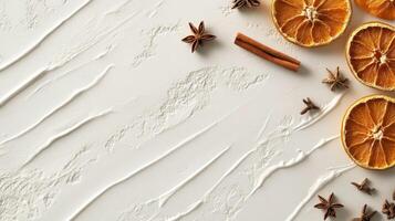 Dried orange slices, star anise, and cinnamon stick on textured white surface photo