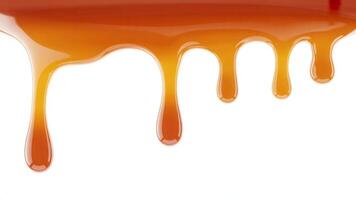 Close up of caramel sauce dripping down against a plain white background surface photo