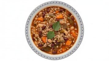 Overhead shot of a bowl of bean and barley soup with carrots and leafy garnish photo