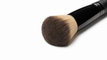 Close up shot of a makeup brush with black handle on a plain white background photo