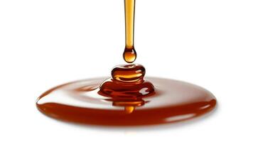 Close up shot of caramel syrup pouring onto a surface with a white background visible behind it photo