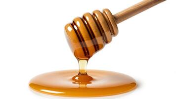 Close up of a wooden honey dipper with honey dripping onto a white surface creating a puddle photo