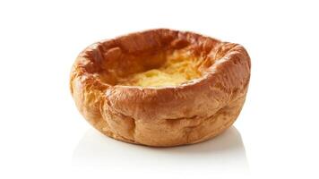 Close up of a single yorkshire pudding with a golden brown crust on white background photo